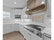 A kitchen with white cabinets, light countertops, stainless steel appliances, and a stainless steel range hood at 543 Allessandra Dr, Clayton, NC 27527