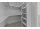 Walk-in closet with built-in shelving, natural light, and neutral carpet at 543 Allessandra Dr, Clayton, NC 27527
