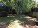 Landscaped backyard with mature trees and grass providing a peaceful outdoor space at 5893 Shady Grove Cir, Raleigh, NC 27609