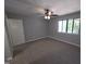 Spacious bedroom featuring neutral carpeting, a ceiling fan, a bright window, and closet door at 5893 Shady Grove Cir, Raleigh, NC 27609