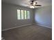 Spacious bedroom featuring neutral carpeting, a ceiling fan, and a bright window at 5893 Shady Grove Cir, Raleigh, NC 27609