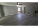 Open living room with sleek gray floors, a ceiling fan, and a view into the kitchen at 5893 Shady Grove Cir, Raleigh, NC 27609
