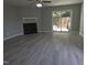 Open living room with sleek gray floors, fan, fireplace, and sliding door to the fenced back yard at 5893 Shady Grove Cir, Raleigh, NC 27609