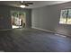 Living room with sleek gray floors, fan, bright window, and sliding door to fenced backyard at 5893 Shady Grove Cir, Raleigh, NC 27609