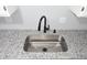 Close-up of a stainless steel sink with a modern black faucet and granite countertop at 5893 Shady Grove Cir, Raleigh, NC 27609