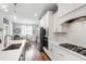 Modern kitchen with white cabinets, stainless steel appliances, and island with eat in seating and bright pendant lights at 690 Great Ridge Pkwy, Chapel Hill, NC 27516