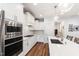 Bright kitchen featuring white cabinets, stainless steel appliances, and a center island with pendant lighting at 690 Great Ridge Pkwy, Chapel Hill, NC 27516