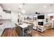 Open-concept kitchen and living room featuring an island with seating, fireplace, and stainless steel appliances at 690 Great Ridge Pkwy, Chapel Hill, NC 27516