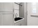 Well-organized utility sink with gray cabinets and storage space at 690 Great Ridge Pkwy, Chapel Hill, NC 27516