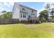 Expansive backyard featuring a wooden deck, complemented by mature trees and privacy fence, perfect for entertaining and outdoor activities at 767 Omaha Dr, Broadway, NC 27505