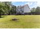 Expansive backyard with lush lawn, fire pit, privacy fence, and mature trees at 767 Omaha Dr, Broadway, NC 27505