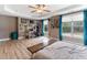 Spacious bedroom featuring a ceiling fan, tray ceiling, office area, and large windows at 767 Omaha Dr, Broadway, NC 27505
