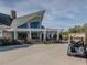 View of the clubhouse exterior, showcasing covered patio, golf carts and lush landscaping at 8 Pin Tail Ct, Pittsboro, NC 27312