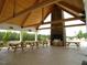 Outdoor pavilion with picnic tables and a stone fireplace with grill, ideal for gatherings at 8 Pin Tail Ct, Pittsboro, NC 27312