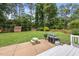 Expansive backyard with green grass, a patio with BBQ grills, and storage sheds at 821 Van Thomas Dr, Raleigh, NC 27615