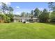 The backyard is spacious and level, with a view of the house, a grill and mature trees at 821 Van Thomas Dr, Raleigh, NC 27615