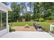 Lush backyard featuring a patio with grill and picnic table, surrounded by mature trees at 821 Van Thomas Dr, Raleigh, NC 27615