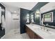 Elegant bathroom with double sinks, modern lighting, and a walk-in glass shower at 821 Van Thomas Dr, Raleigh, NC 27615