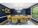 Elegant dining room with modern lighting fixture and a sleek table surrounded by stylish yellow chairs at 821 Van Thomas Dr, Raleigh, NC 27615