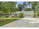Inviting single-story home with an attached two-car garage and long driveway lined with green trees at 821 Van Thomas Dr, Raleigh, NC 27615