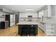 Well-lit kitchen with white cabinets, granite countertops, a central island, and modern appliances at 821 Van Thomas Dr, Raleigh, NC 27615