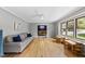 Bright living room with large windows, light-gray walls, ceiling fan, and beautiful hardwood flooring at 821 Van Thomas Dr, Raleigh, NC 27615