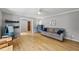 Spacious living room with light-gray walls, hardwood floors, ceiling fan, and comfortable seating arrangement at 821 Van Thomas Dr, Raleigh, NC 27615