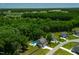 Aerial view showcasing a home, a swimming pool, lush greenery, and the surrounding neighborhood at 8341 Running Fern Way, Willow Springs, NC 27592