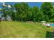 A meticulously maintained backyard with ample green space, landscaping, and an in-ground pool at 8341 Running Fern Way, Willow Springs, NC 27592