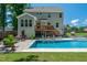 Stunning backyard featuring a pool, lounge area, lush landscaping, and an outdoor living space with plenty of seating at 8341 Running Fern Way, Willow Springs, NC 27592