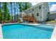 Enjoy the outdoors with a backyard pool, deck, patio area with seating, and a spacious lawn surrounded by mature trees at 8341 Running Fern Way, Willow Springs, NC 27592