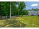 A lovely backyard featuring luscious green lawns, trees, a pool, and a fire pit at 8341 Running Fern Way, Willow Springs, NC 27592