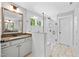 Modern bathroom with a glass-enclosed shower, white cabinets and a decorative mirror at 8341 Running Fern Way, Willow Springs, NC 27592