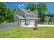 Well-manicured lawn and three-car garage in this two-story home with stone accents at 8341 Running Fern Way, Willow Springs, NC 27592