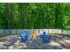 Outdoor fire pit featuring Adirondack chairs, gravel, and wooded scenery at 8341 Running Fern Way, Willow Springs, NC 27592