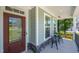 Close-up of the front porch featuring a detailed front door, seating area and view of the neighborhood at 8341 Running Fern Way, Willow Springs, NC 27592