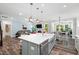 Open-concept floor plan featuring a large kitchen island with seating and stainless steel appliances at 8341 Running Fern Way, Willow Springs, NC 27592