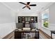 An office area with wood flooring, a ceiling fan, storage shelves, and a view from the window at 8341 Running Fern Way, Willow Springs, NC 27592