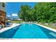 Enjoy the large backyard with a sparkling pool, spacious deck, and a meticulously maintained lawn surrounded by lush trees at 8341 Running Fern Way, Willow Springs, NC 27592