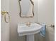 Pedestal sink with a beautiful gilded mirror and gold hardware adds elegance to the space at 8412 Old Deer Trl, Raleigh, NC 27615