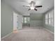Bright bedroom with neutral carpet and green walls, enhanced by a ceiling fan and natural light at 8412 Old Deer Trl, Raleigh, NC 27615