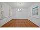 Dining room featuring hardwood floors, natural light, and modern chandelier at 8412 Old Deer Trl, Raleigh, NC 27615