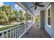 Inviting front porch featuring white railings, ceiling fans, and a view of the landscaped yard and quiet street at 8412 Old Deer Trl, Raleigh, NC 27615