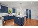 Bright and airy kitchen featuring blue cabinets, marble countertops, a large island, and hardwood floors at 8412 Old Deer Trl, Raleigh, NC 27615