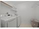 Efficient laundry room with modern washer and dryer, white shelving, and patterned tile flooring at 8412 Old Deer Trl, Raleigh, NC 27615