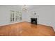 Classic living room featuring a marble fireplace, modern chandelier, hardwood floors, and natural light from shuttered windows at 8412 Old Deer Trl, Raleigh, NC 27615