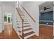 Elegant foyer staircase featuring hardwood steps, white risers and banister and a decorative newel post at 8412 Old Deer Trl, Raleigh, NC 27615