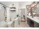 Bright bathroom with tub and shower, modern shelving, and doorway at 9021 Winged Thistle Ct, Raleigh, NC 27617