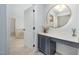 Bathroom vanity and makeup area featuring round mirror and neutral decor at 9021 Winged Thistle Ct, Raleigh, NC 27617