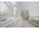Bathroom featuring dual sinks, a shower, and a separate bathtub at 9021 Winged Thistle Ct, Raleigh, NC 27617